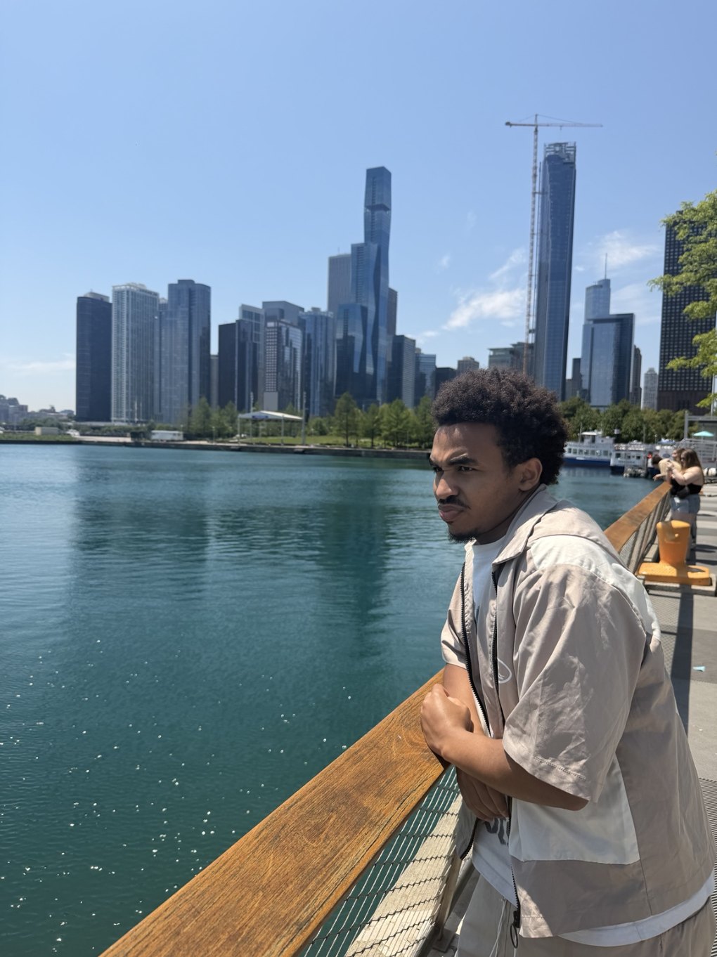 Ayub Mohamed at the Chicago waterfront with the skyline behind him
